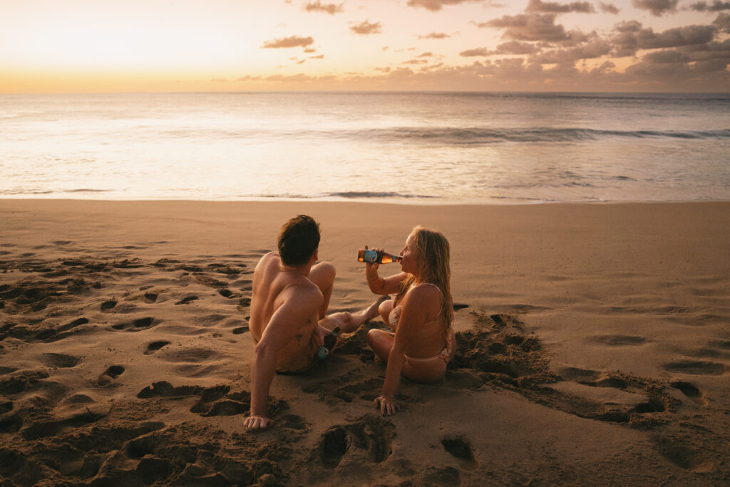 couple sharing a beer on the beach