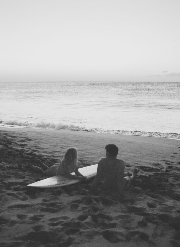 couple on a surfboard on black and white film