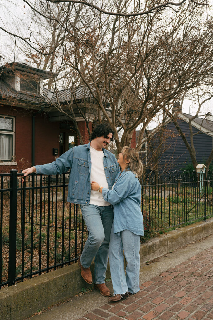 Nashville couple leaning against a fence 