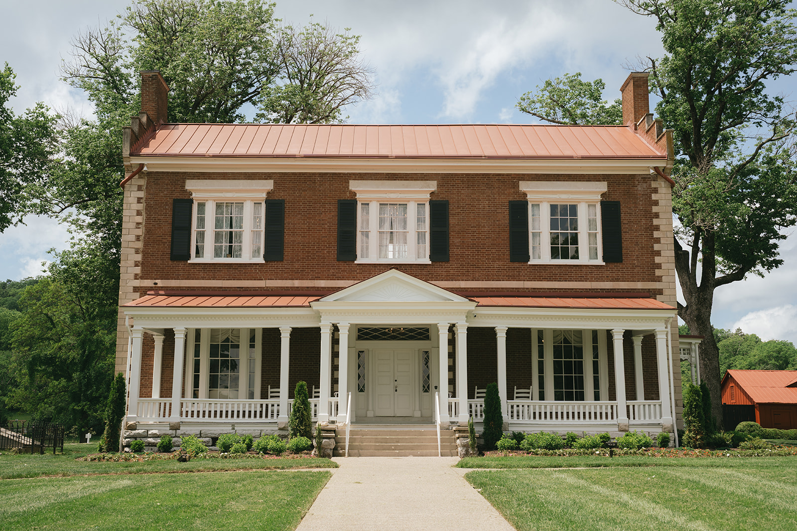 A look at the front facade of a brick home with large porch at one of the Nashville Wedding Venues
