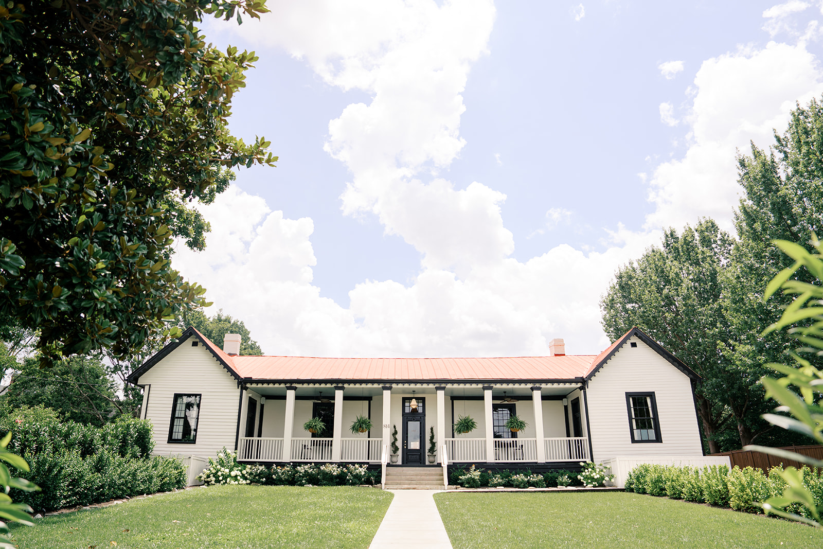 A white building with large front porch and lawn at one of the places to elope in Nashville