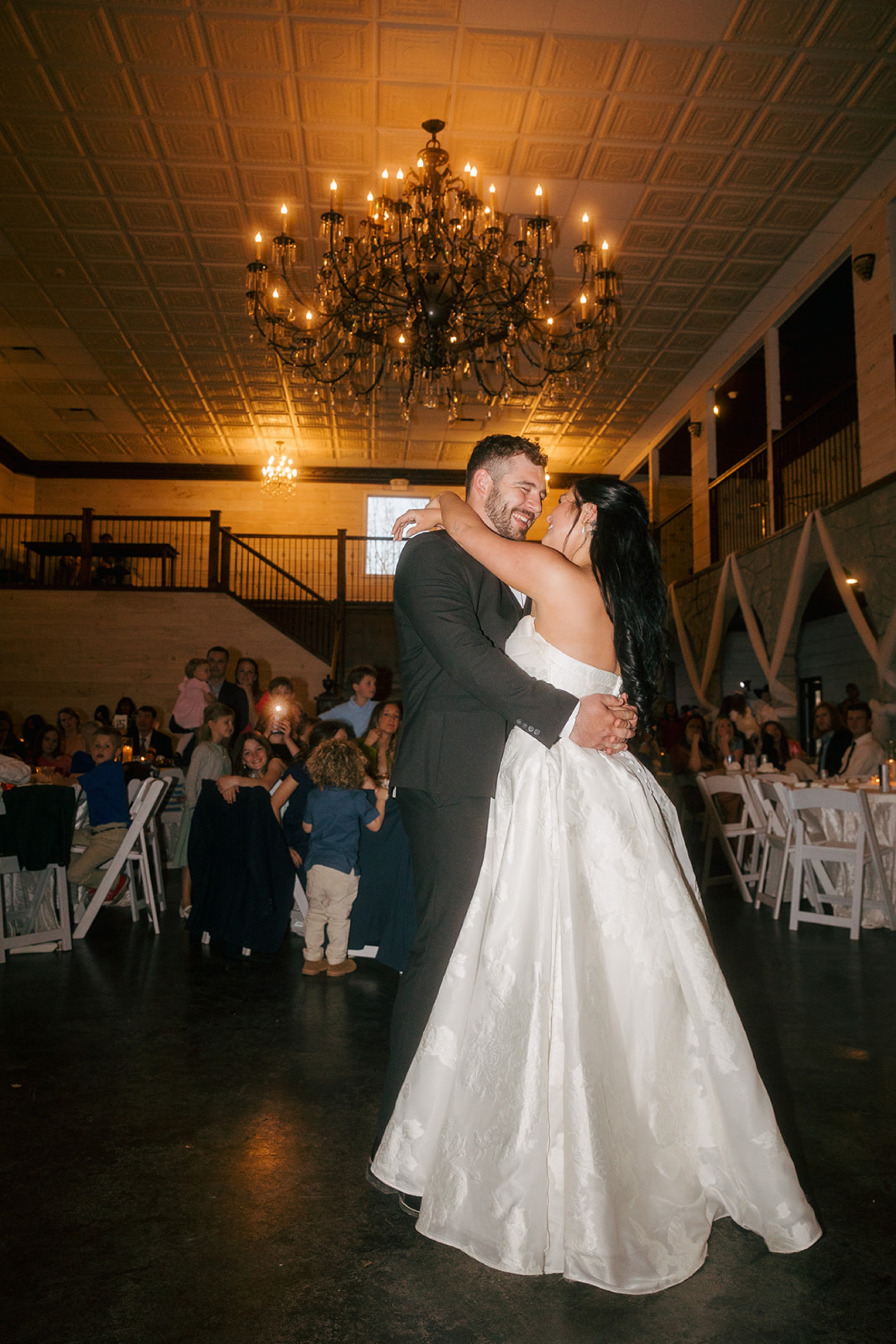 Newlyweds dance under the large Tayvin Gardens chandelier