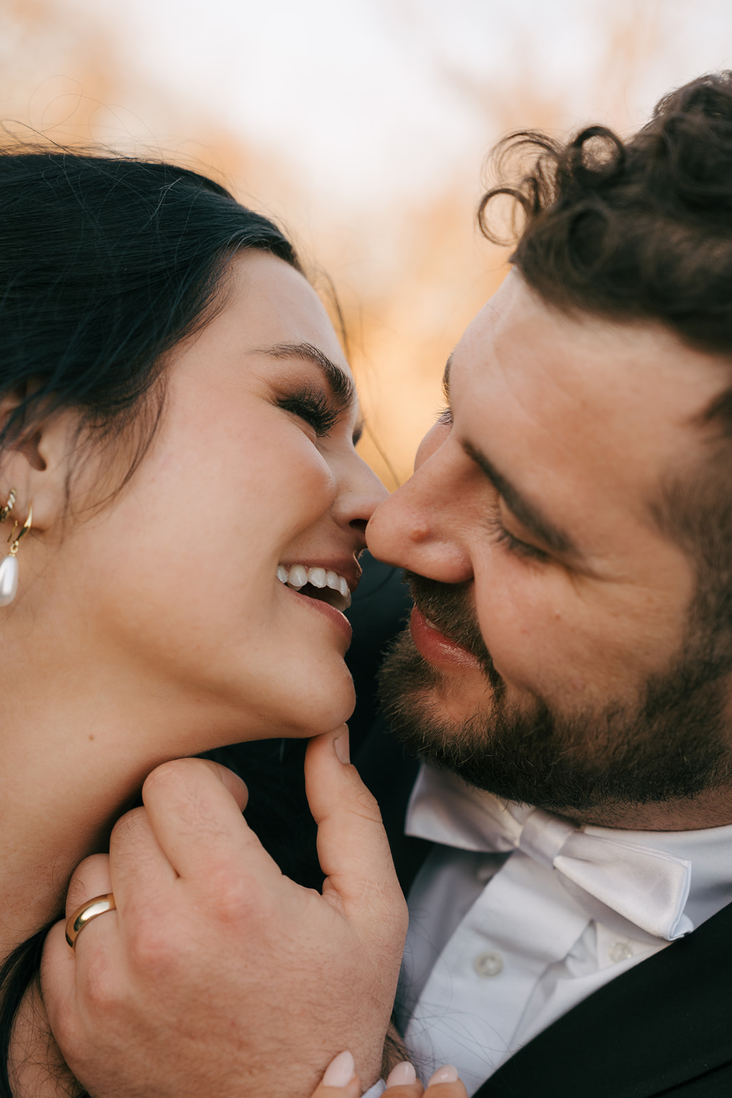 Newlyweds lean in for a happy kiss at sunset