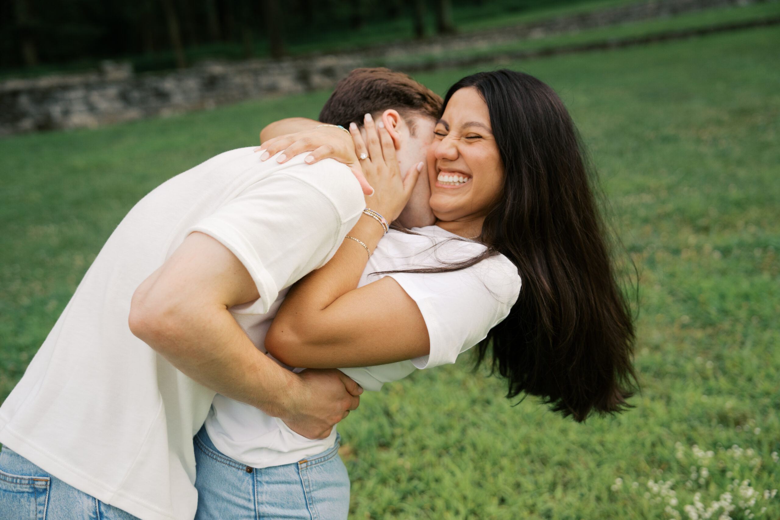 Man kissing a woman's neck as she's laughing with her head thrown back. 