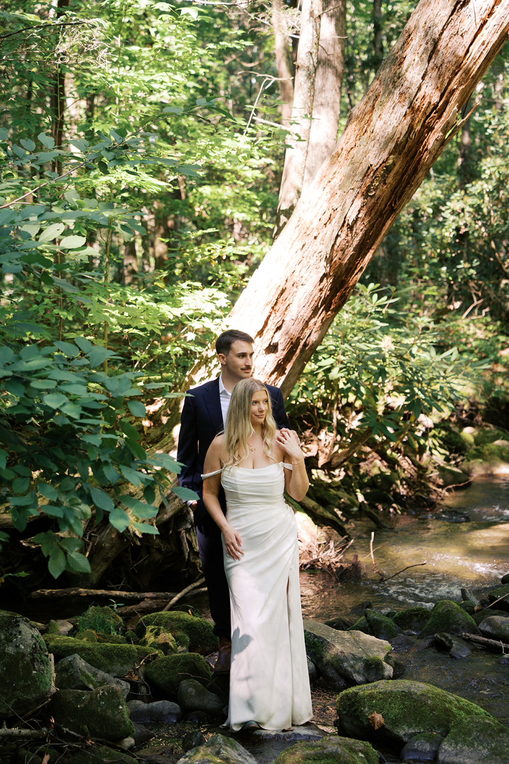 A bride and groom snuggle on a creek in the Smokies