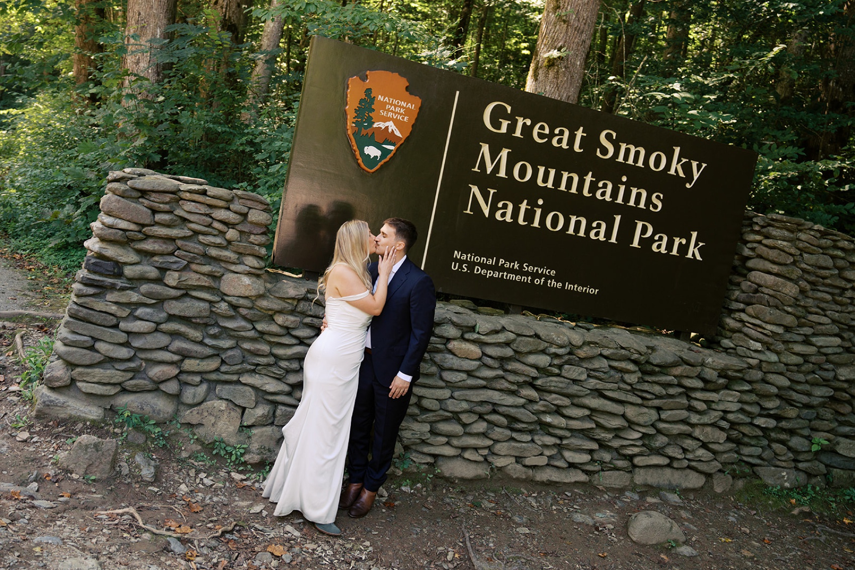 Newlyweds kiss under the Geeat Smoky Mountains National Park welcome sign