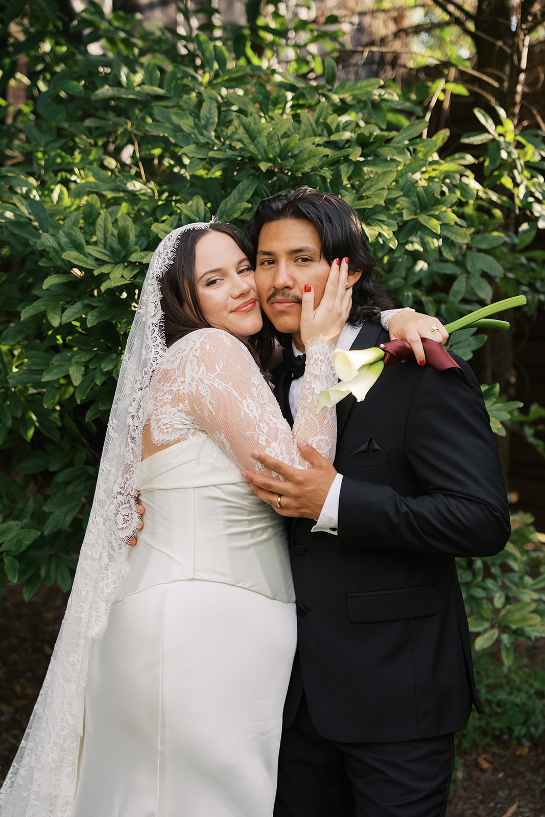 A bride snuggles cheek to cheek with her groom in a garden at one of the small wedding venues in Nashville