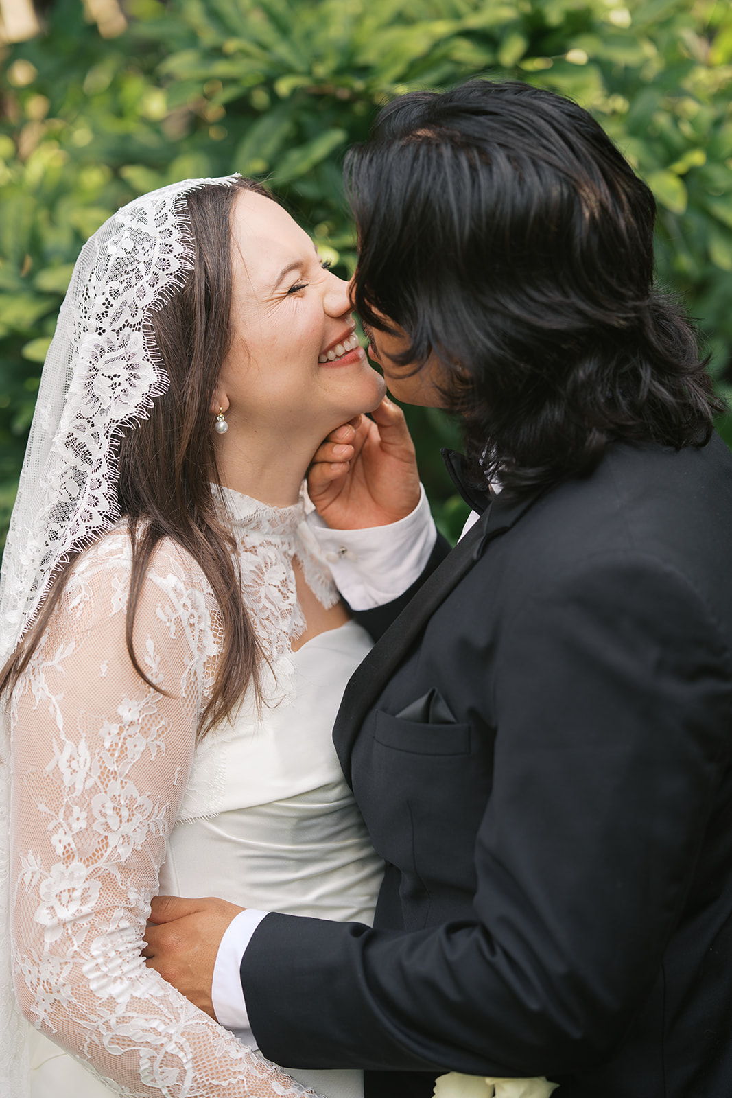 Newlyweds lean in for a happy kiss in a garden at one of the small wedding venues in Nashville