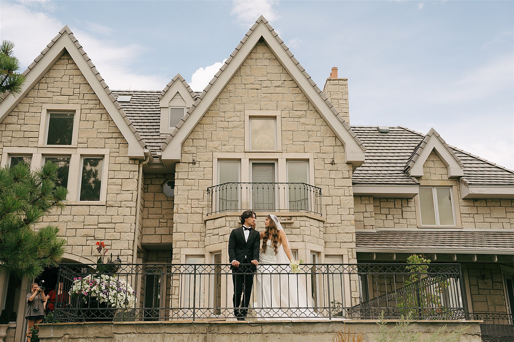 Newlyweds look out over the Greystone Castle wedding venue pastures from a balcony