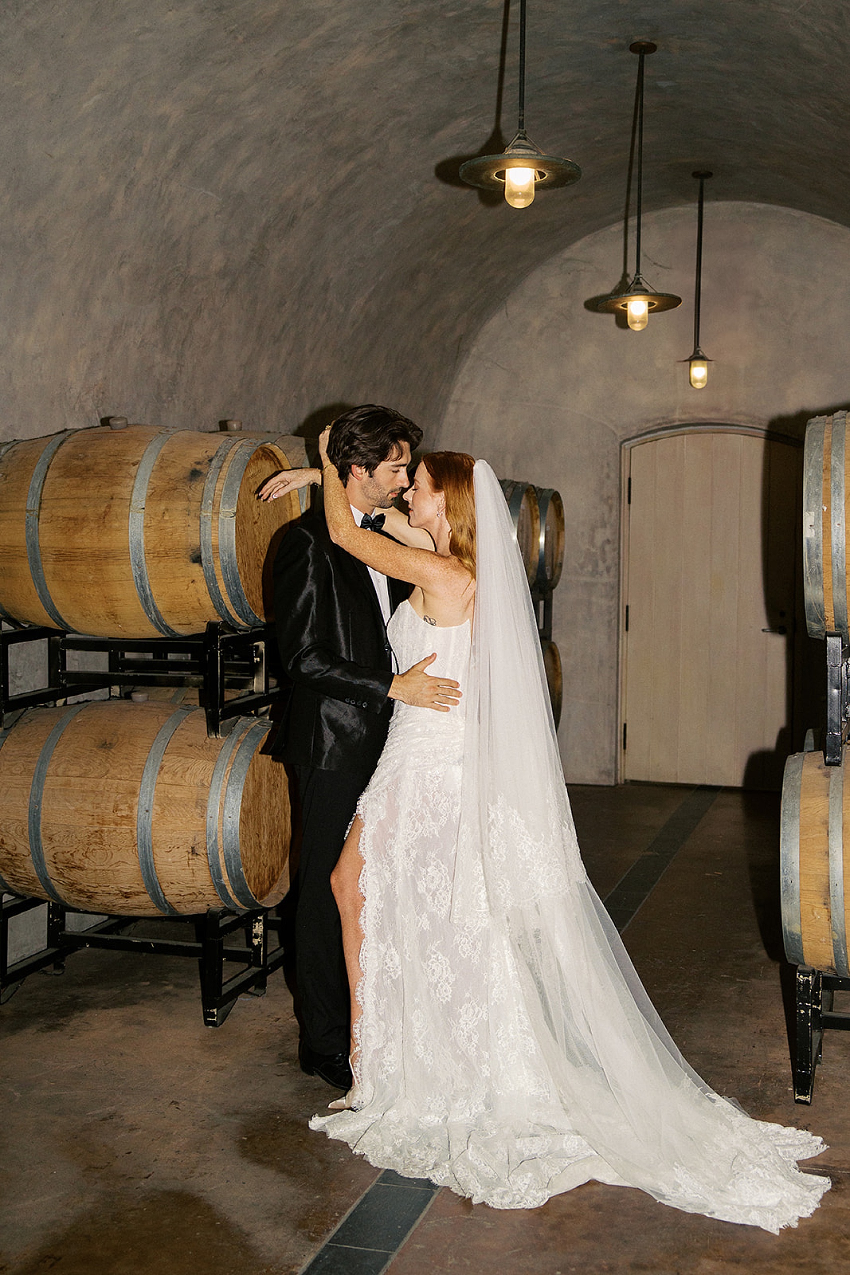 Newlyweds share a dance in the wine barrel room