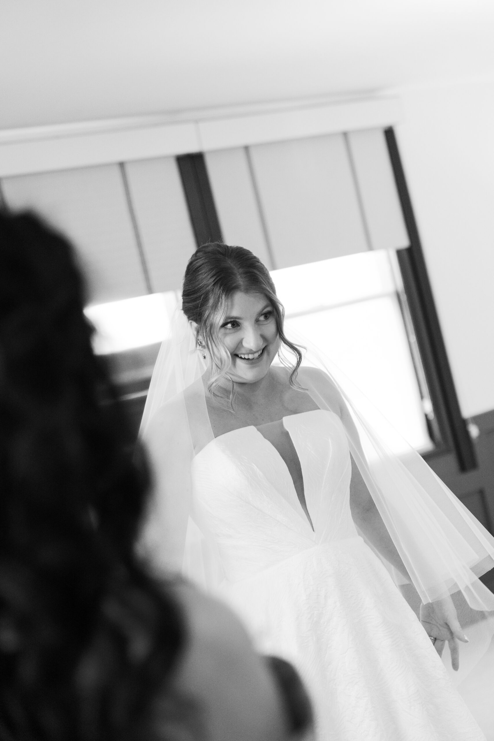 A bride looking in the mirror with her wedding dress on for the first time at her wedding day in hotel morgan west virginia