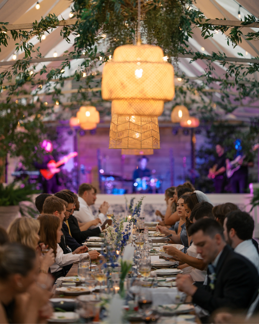 a wedding party eating dinner with ambient lighting at long hollow gardens