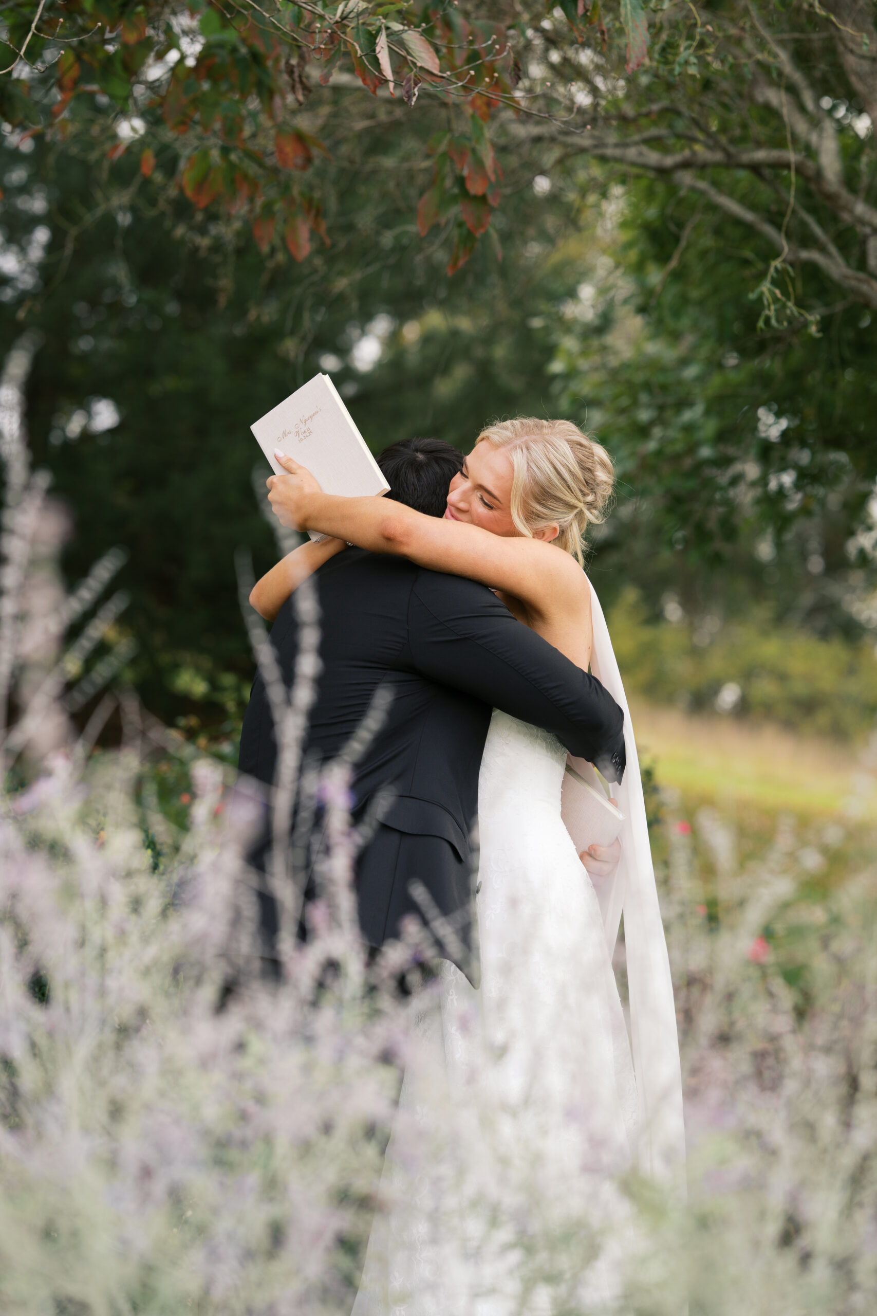 A bride and groom crying next to lavender flowers as they say their vows.