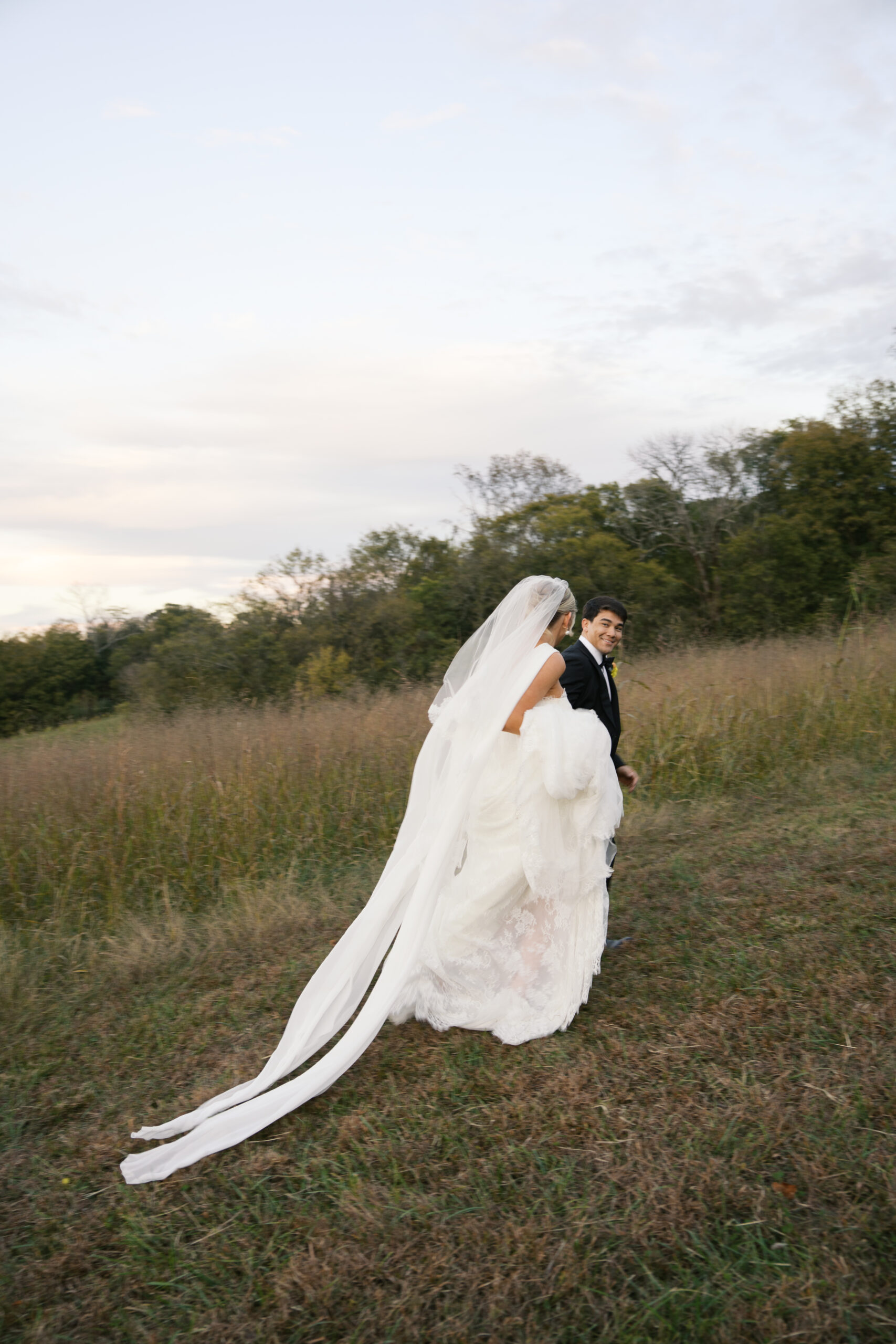 a bride and groom during golden hour at stone haven in section alabama running up a hill laughing