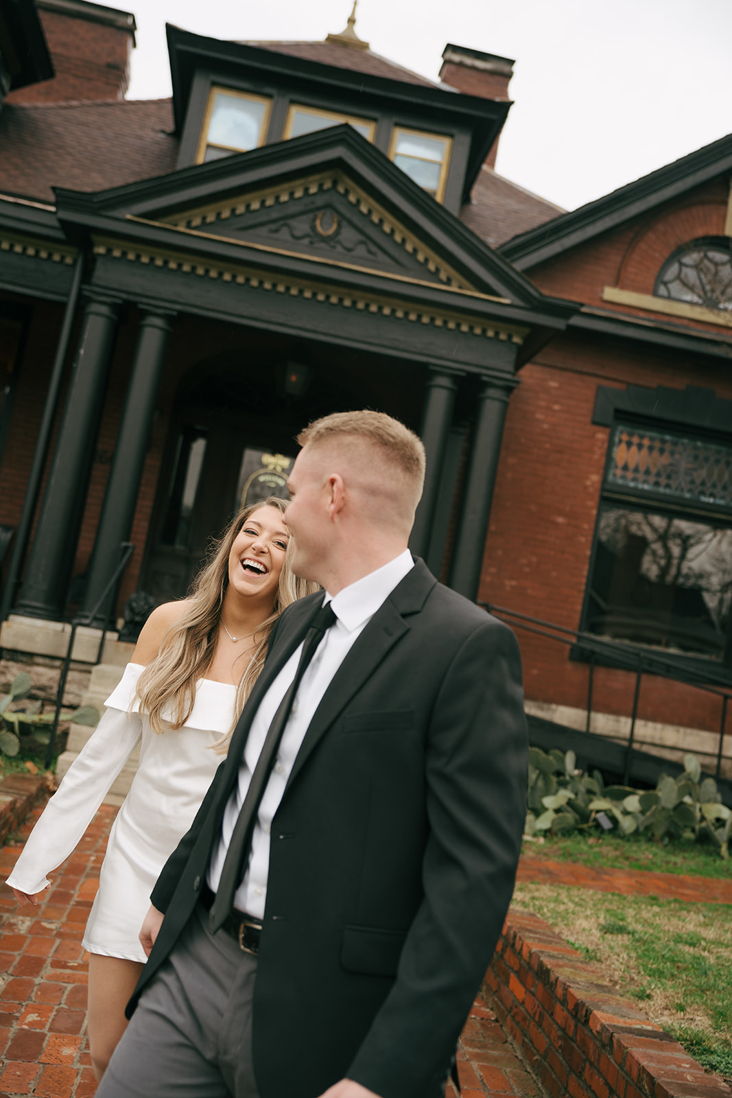 couple laughing out front of the urban cowboy in nashville during their engagement session