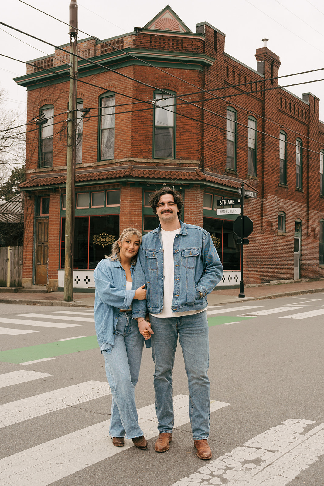 a couple standing in the crosswalk wearing all denim in germantown nashville during their engagement session