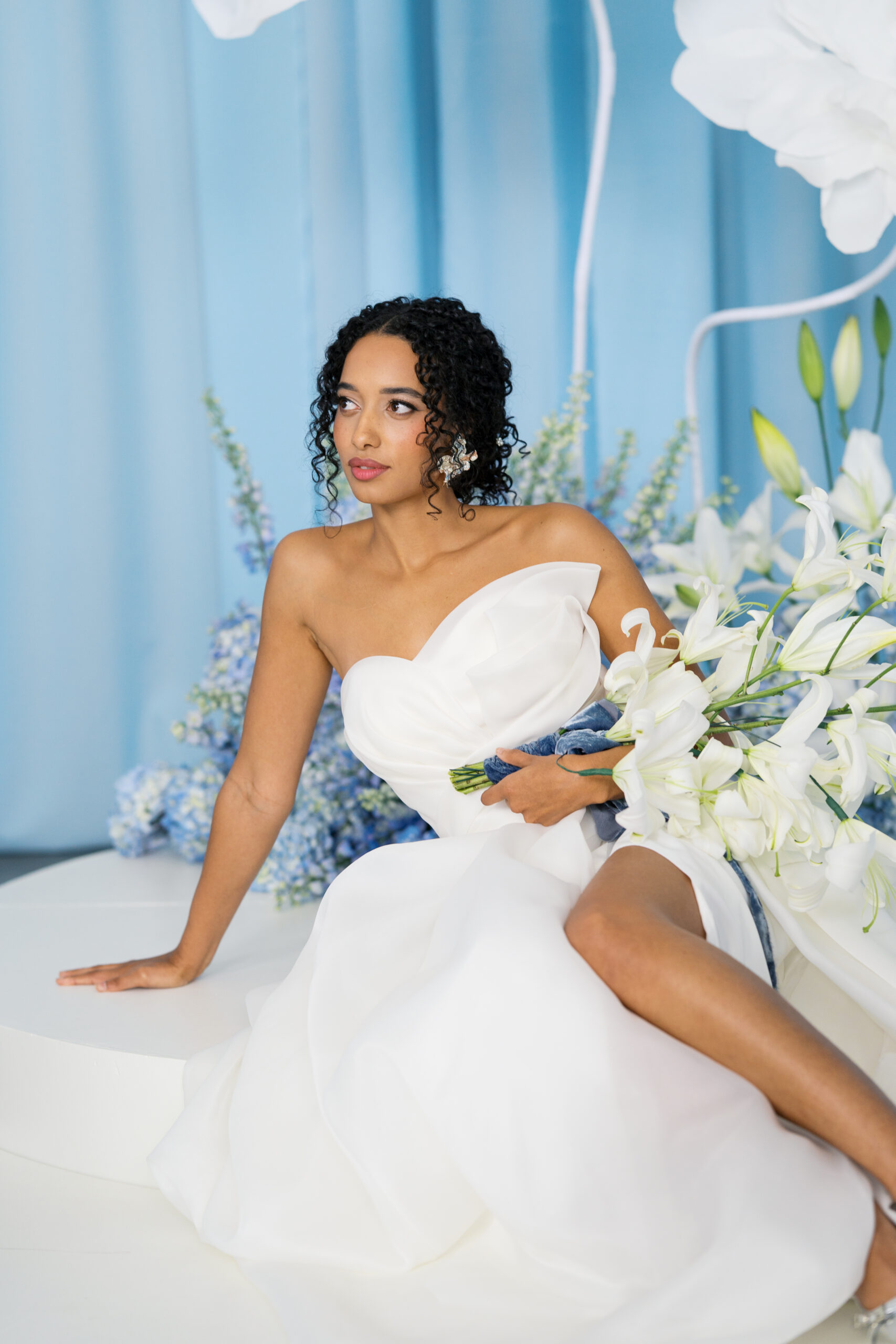 a bride sitting with her bouquet of white orchids looking off into the distance at her wedding in nashville