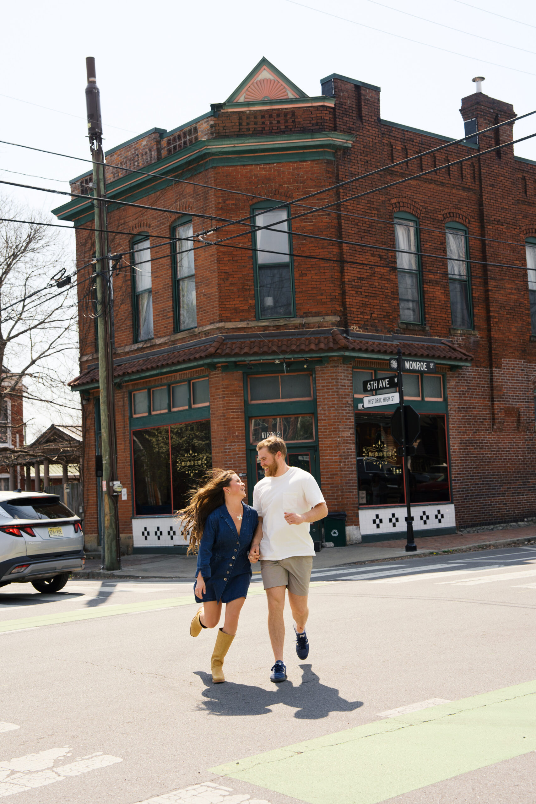 Couple holds hands as they run across a downtown street in Germantown, TN.