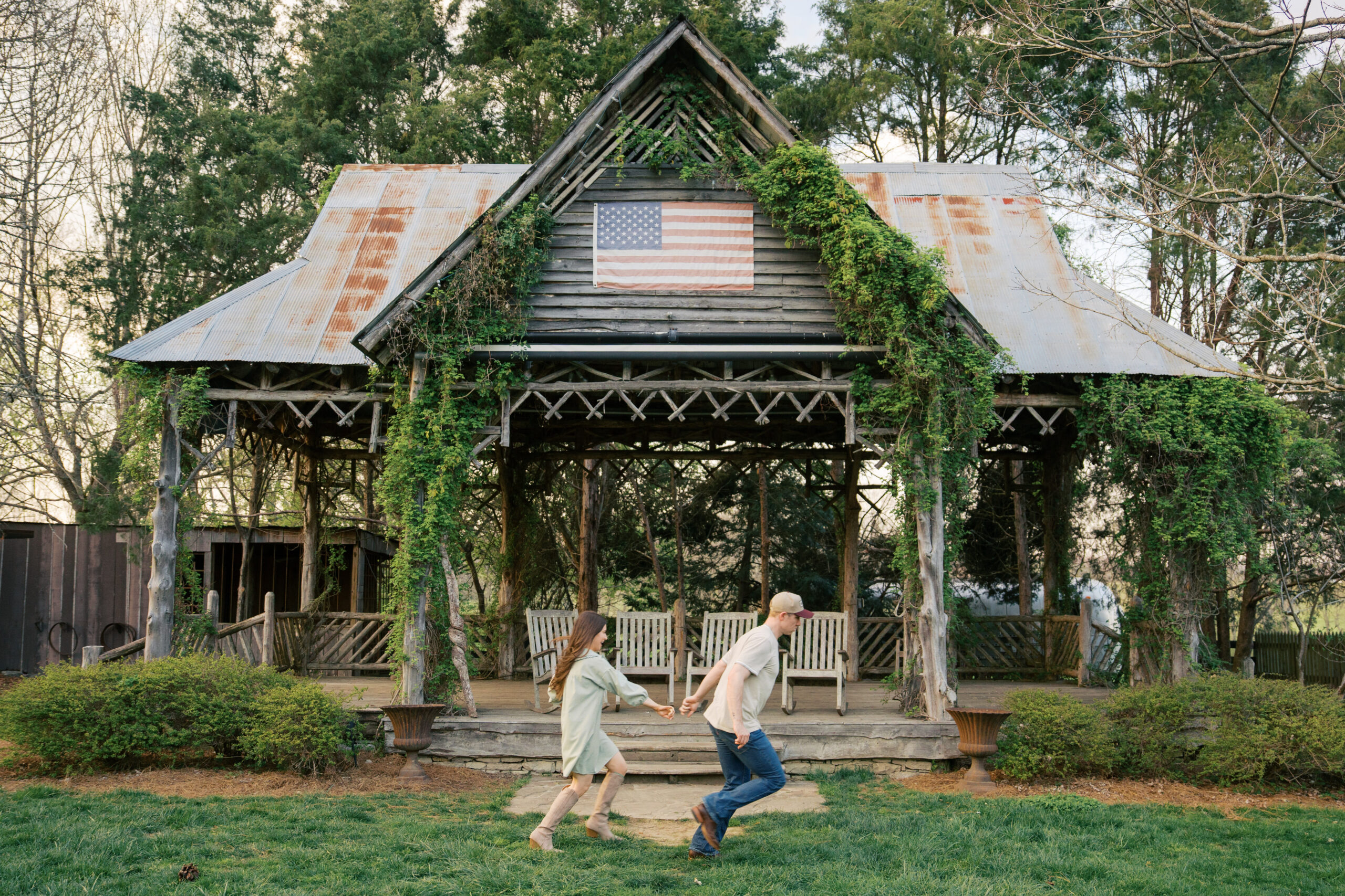 couple holding hands and running in front of the liepers fork pavilion during their engagement session
