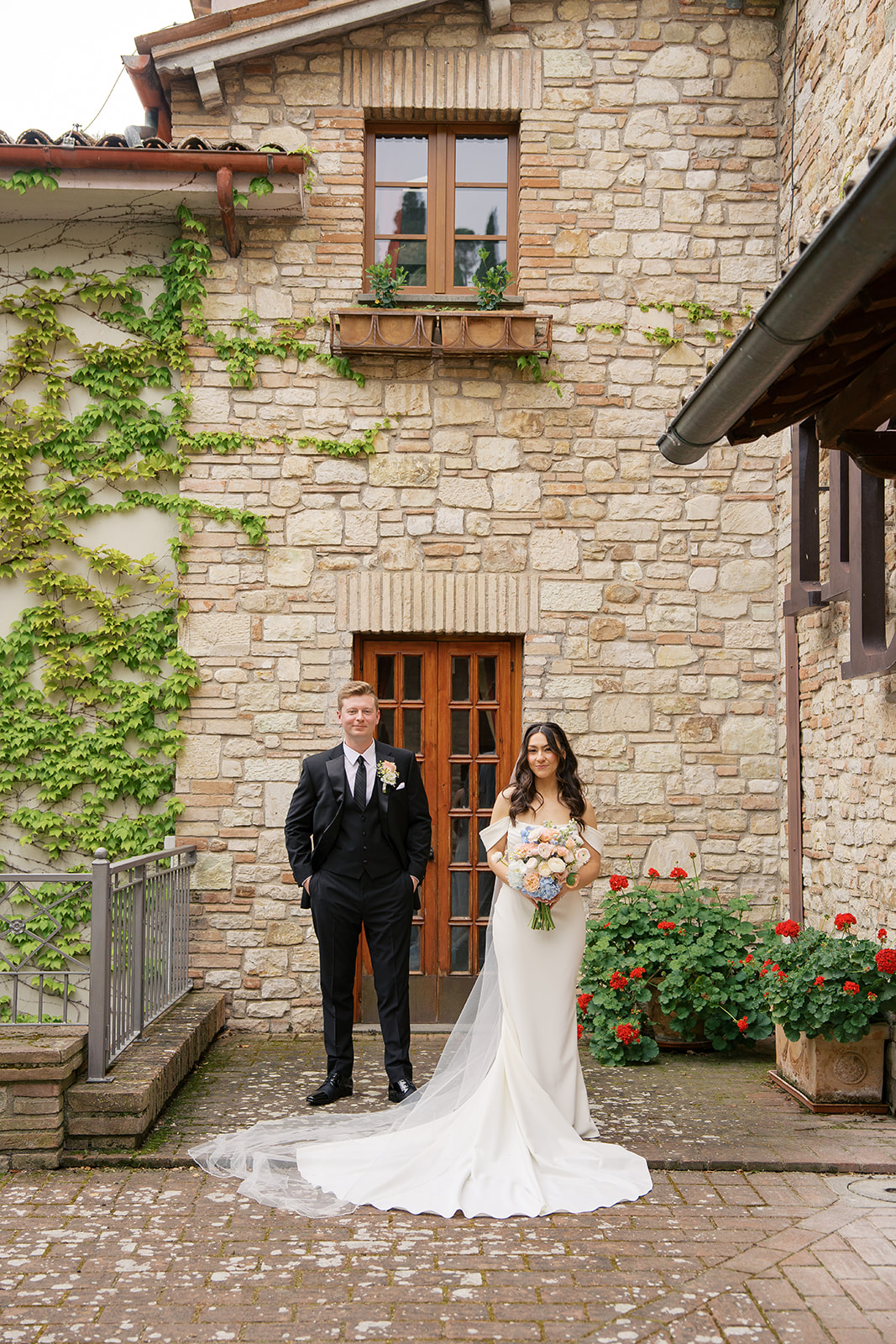 A bride and grooms portrait at their wedding venue in umbria italy with ivy and stone walls