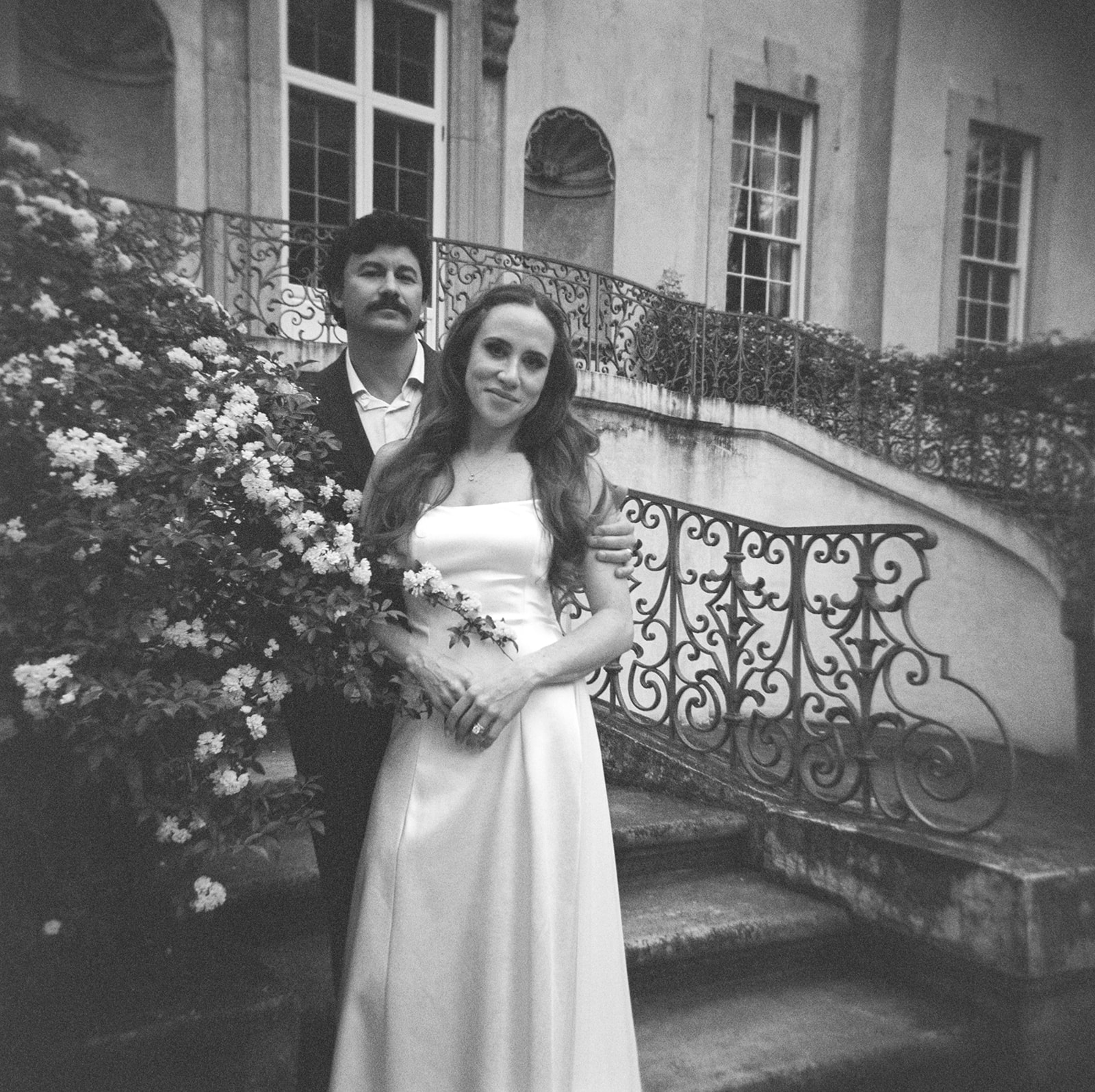 A couple photographed on film in their wedding attire at the swan house.