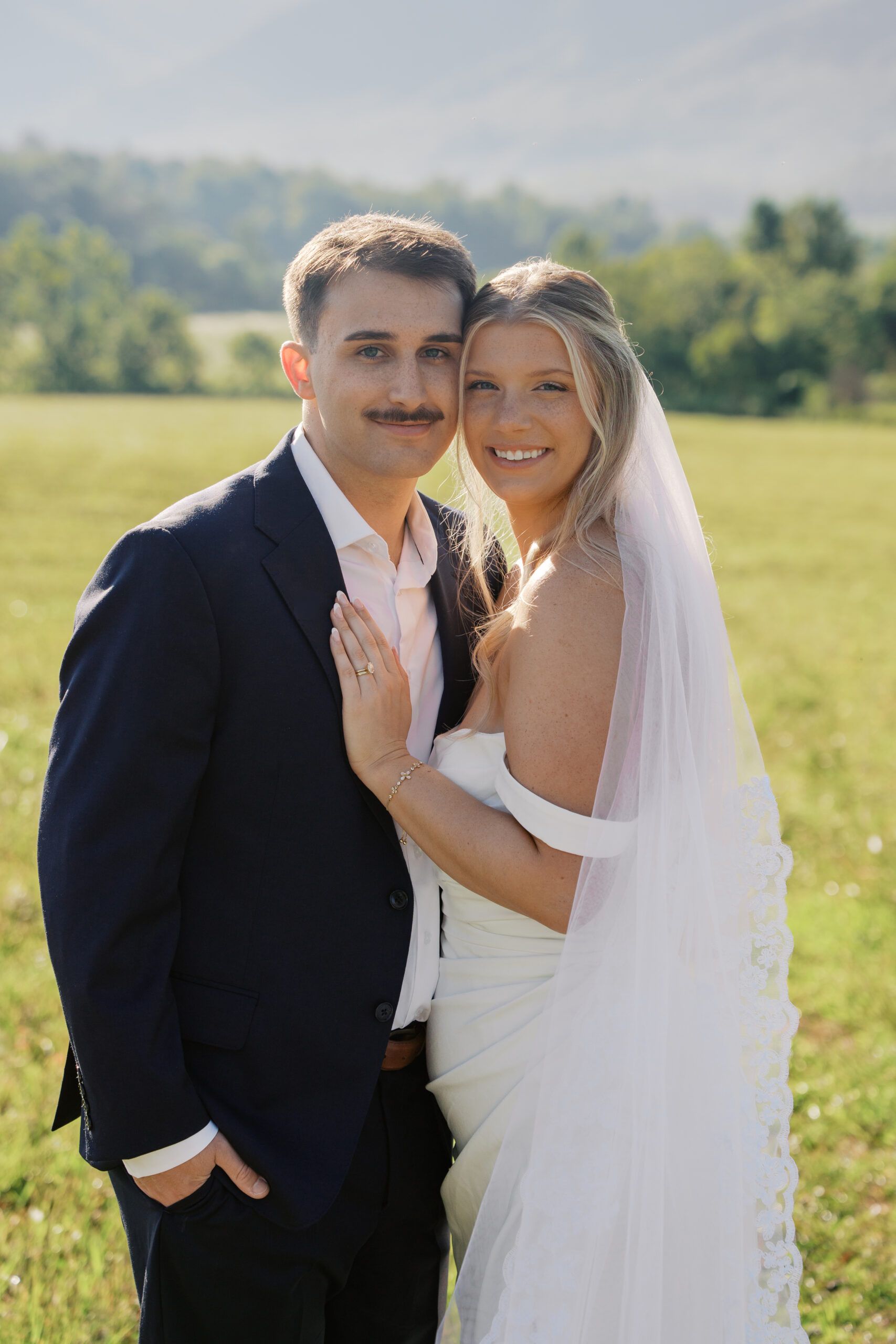 A bride and groom looking at the camera smiling during their elopement in the smoky mountains