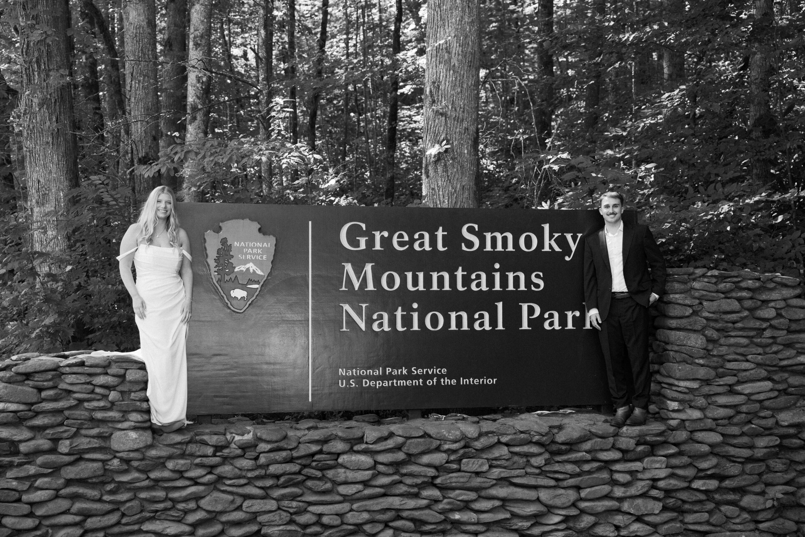 A couple standing next to the great smoky mountains national park sign during their elopement