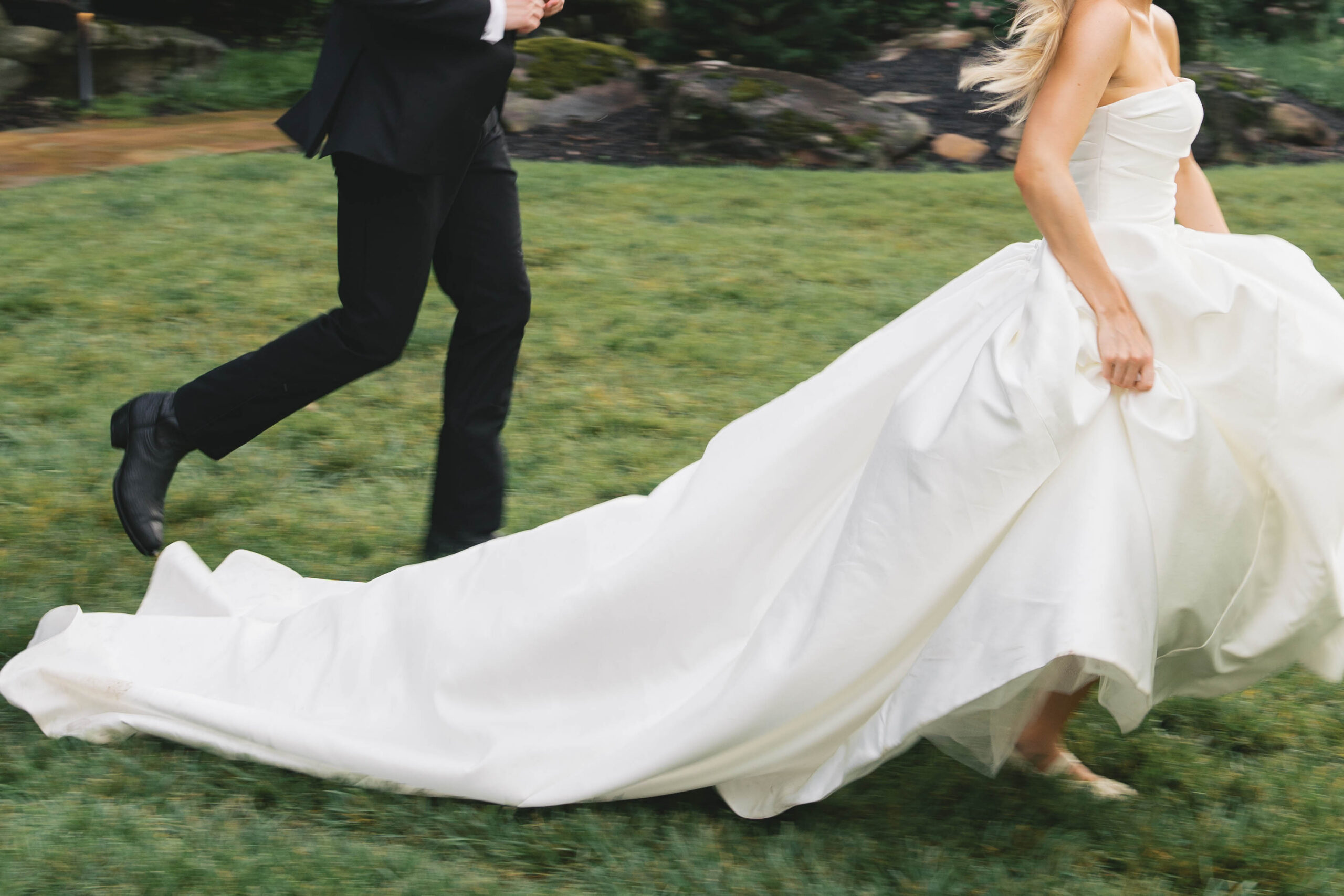 a bride and groom running in grass at their luxury wedding in tennessee.