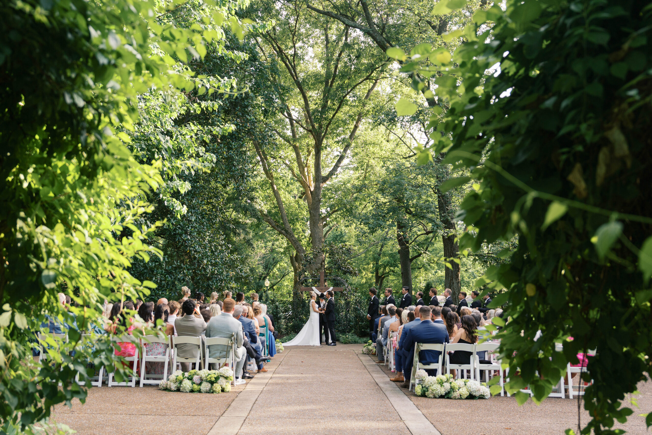 A wedding ceremony photographed through trees in nashville tennessee.