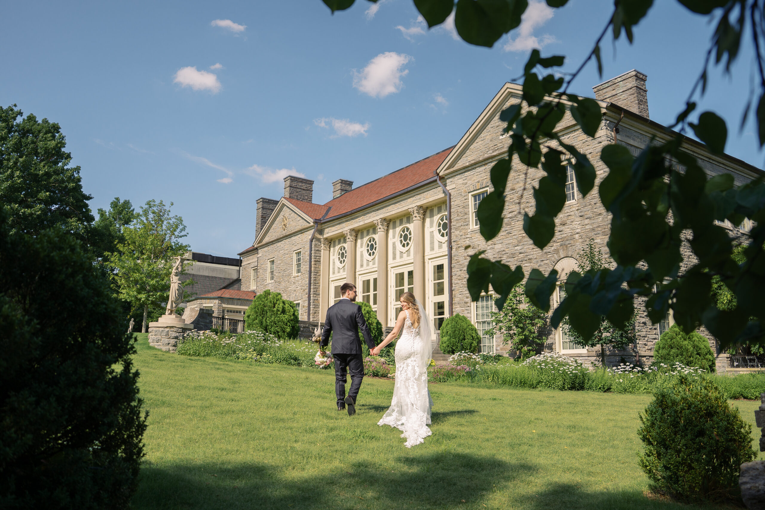 A couple getting married at cheekwood estate and gardens in nashville tennessee. the bride is looking over her shoulder back at the camera. 