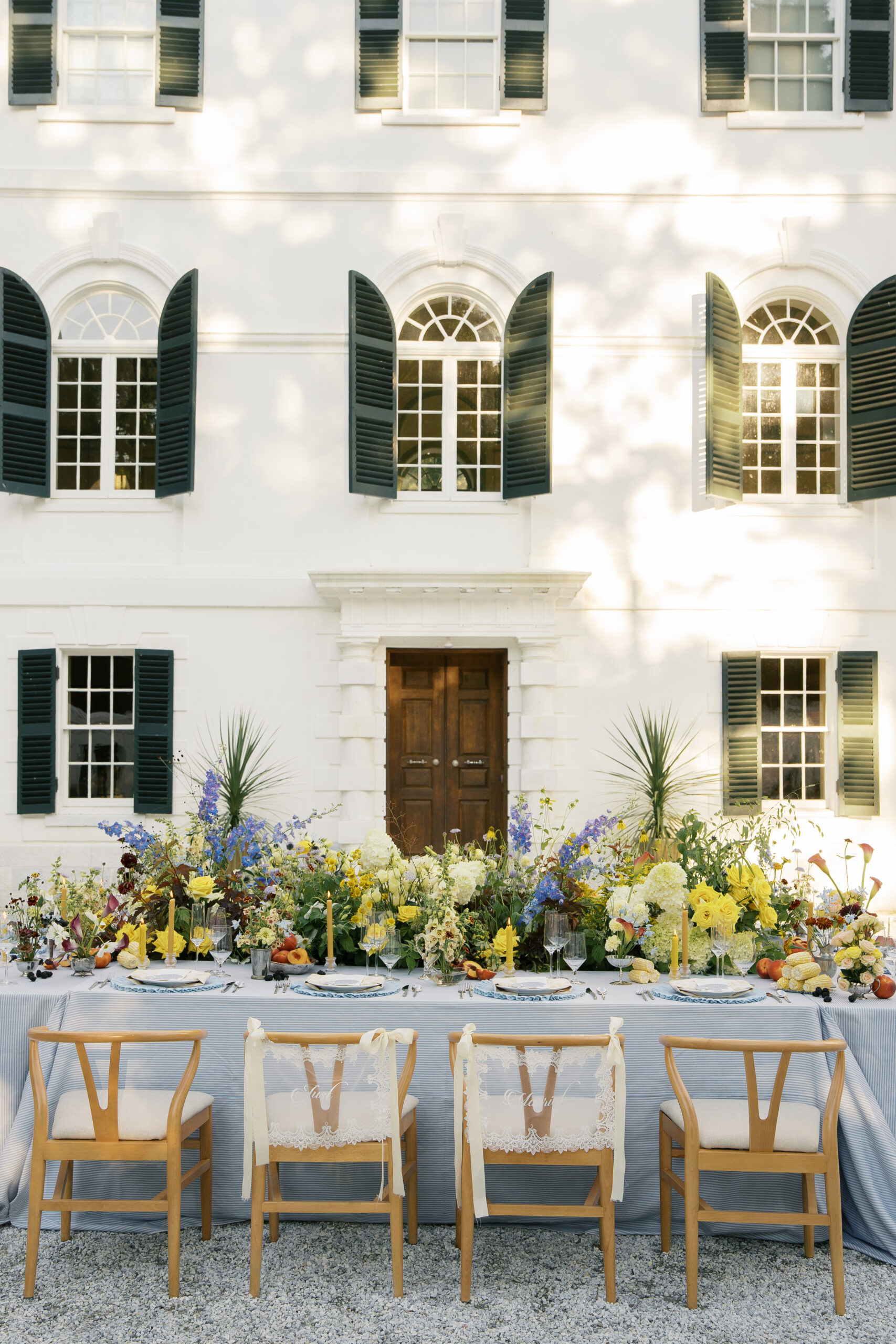 A table cape at the mount in Lenox Massachusetts filled with blue and yellow flowers. Photography by Jaimee Raneigh Photo.