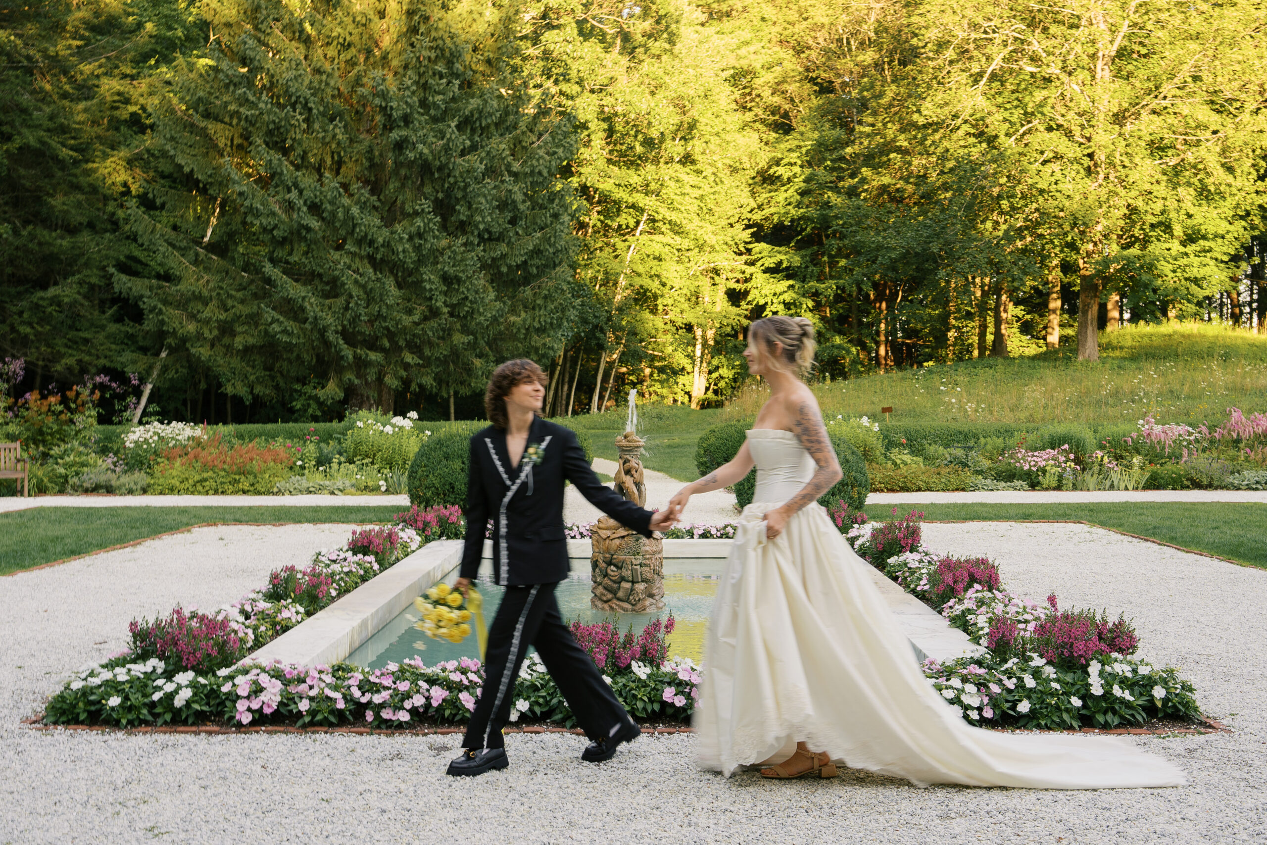 Two brides holding hands running past the camera to create a motion blur effect at their wedding in western massachusetts.