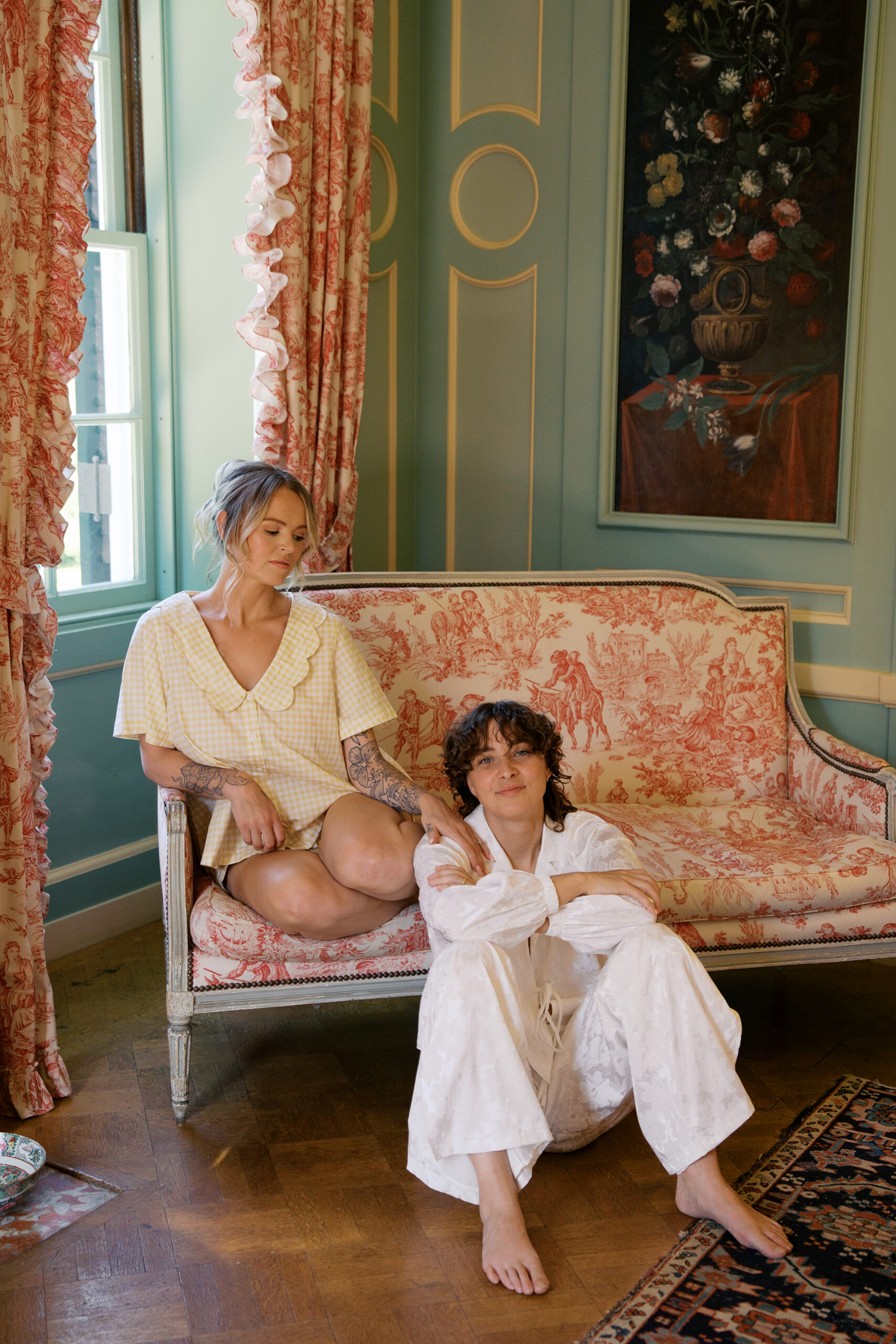 Two brides inside the mount wedding venue in the Berkshires in white pajamas before their wedding ceremony. photo by Jaimee Raneigh photo.