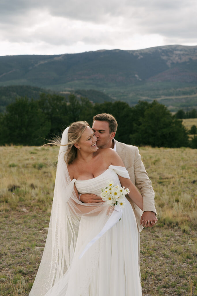 groom kissing the bride on the cheek