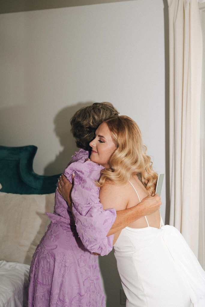 bride and her mom hugging before the garden themed wedding ceremony