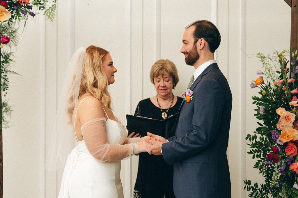 bride and groom holding hands at their wedding ceremony 