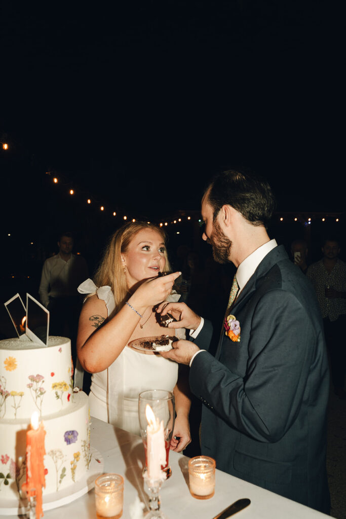 bride and groom trying their wedding cake 