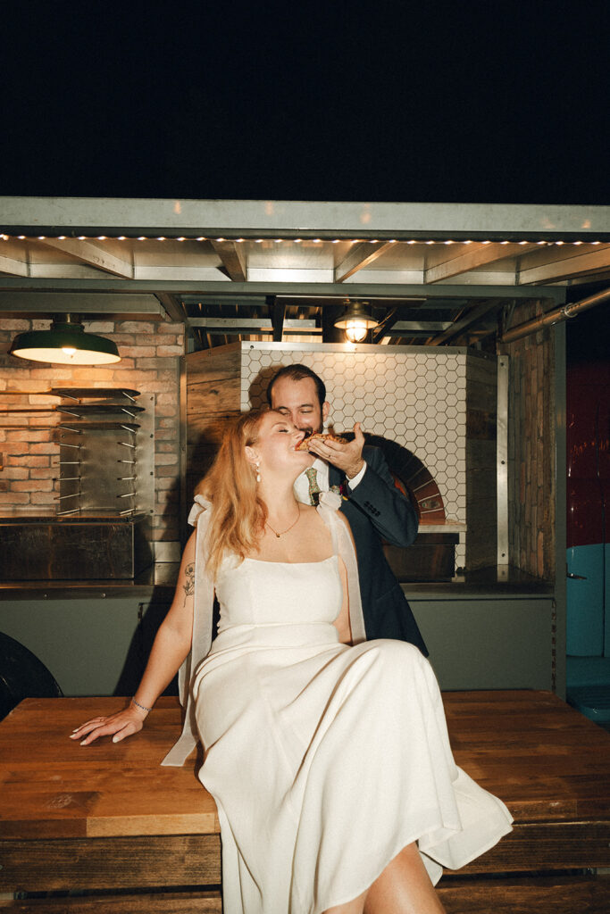 bride and groom eating pizza