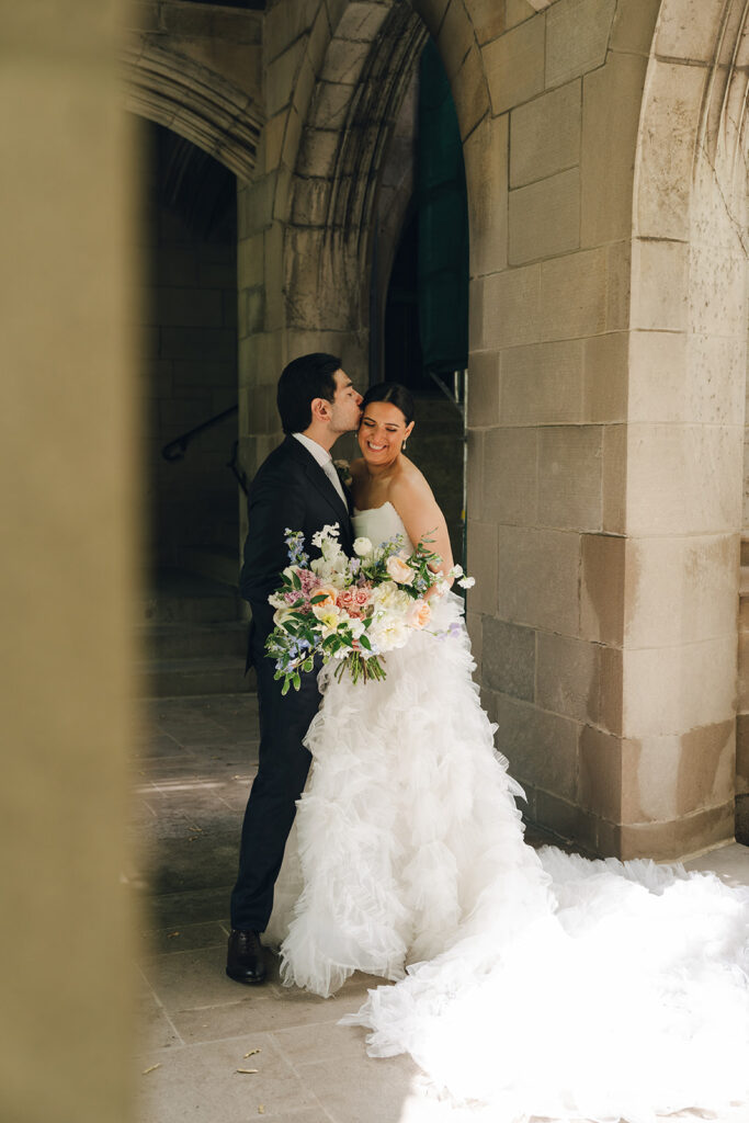 groom kissing the bride on the cheek