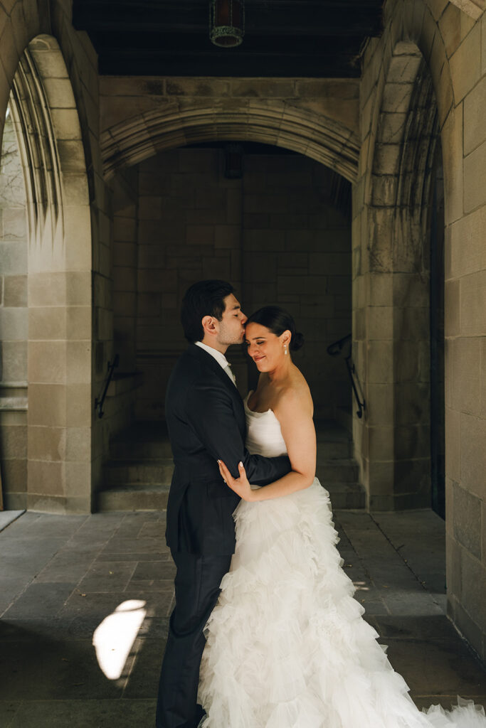 groom kissing the bride on the forehead 