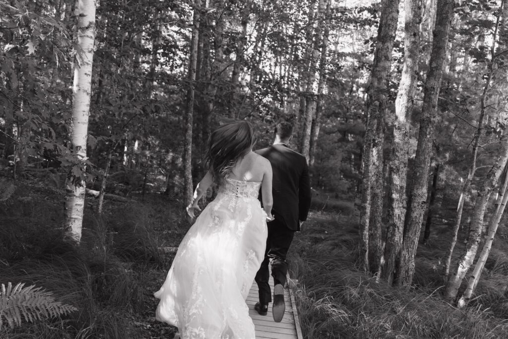 bride and groom running in the forest 