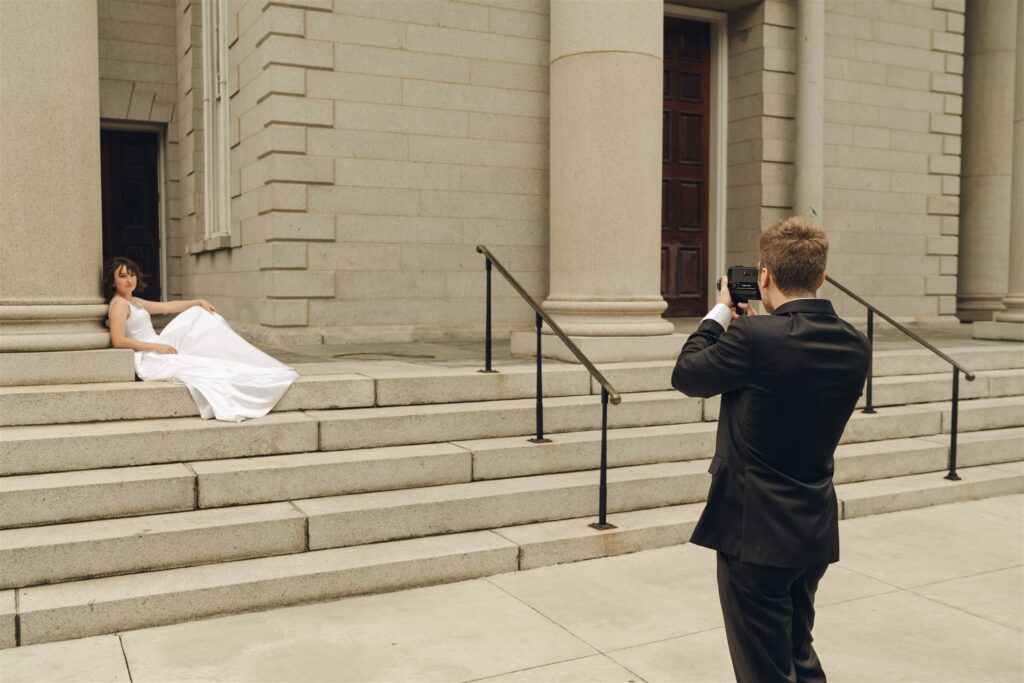 groom taking a picture of the bride 