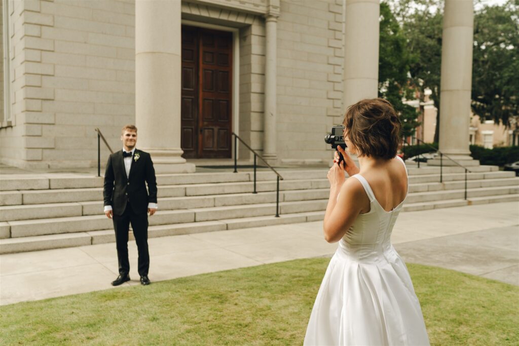 bride taking a picture of the groom