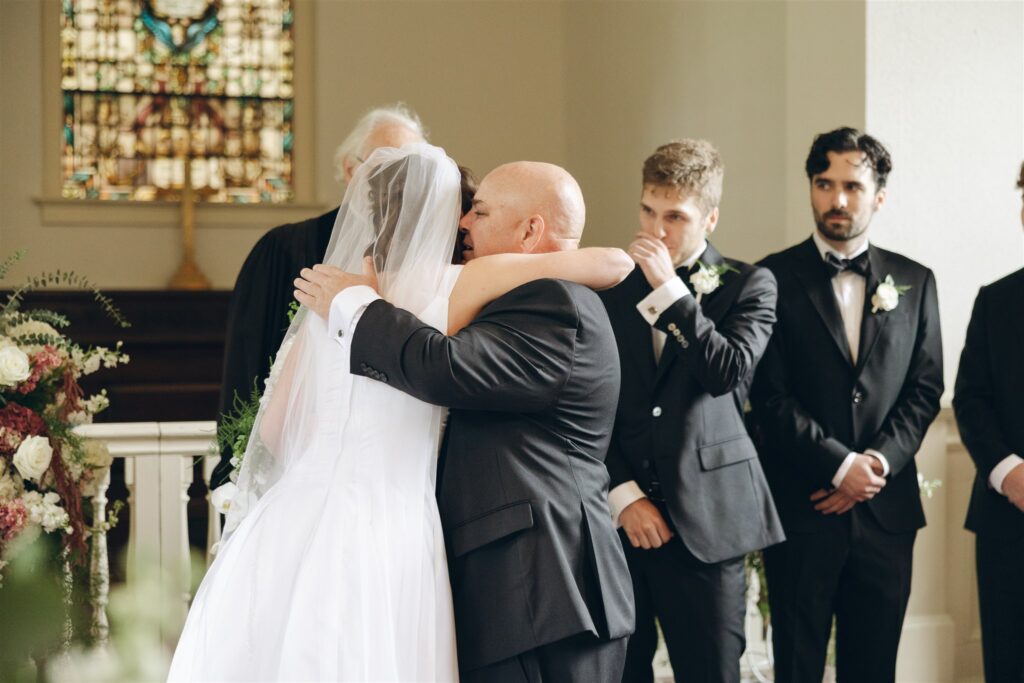 bride and her dad hugging at the altar 