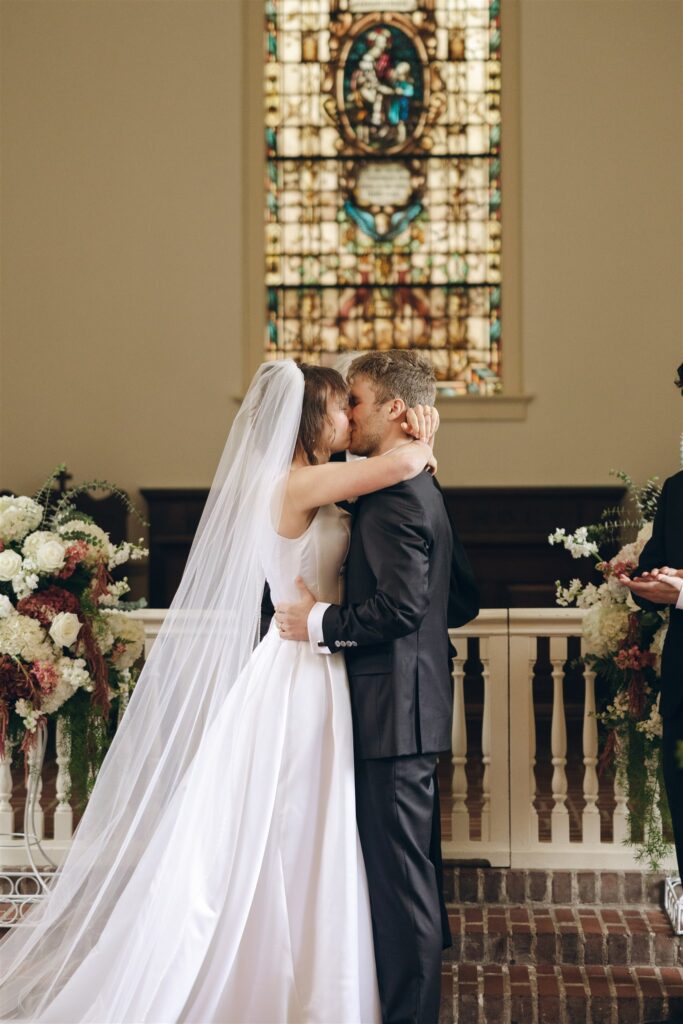 bride and groom kissing after their wedding ceremony 