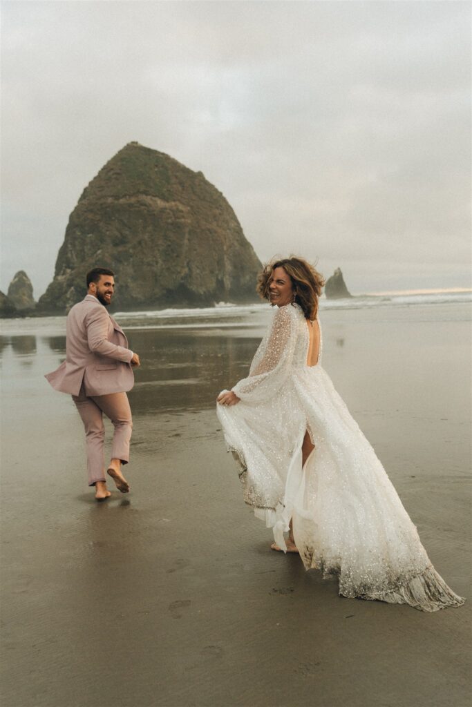 bride and groom running at the beach 