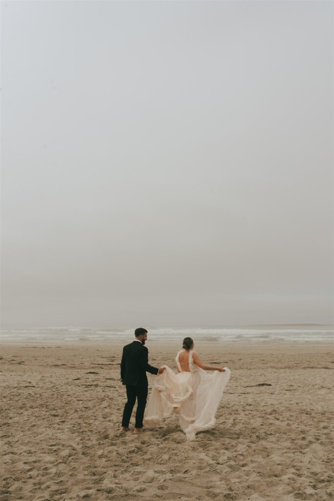 bride and groom running at the beach 