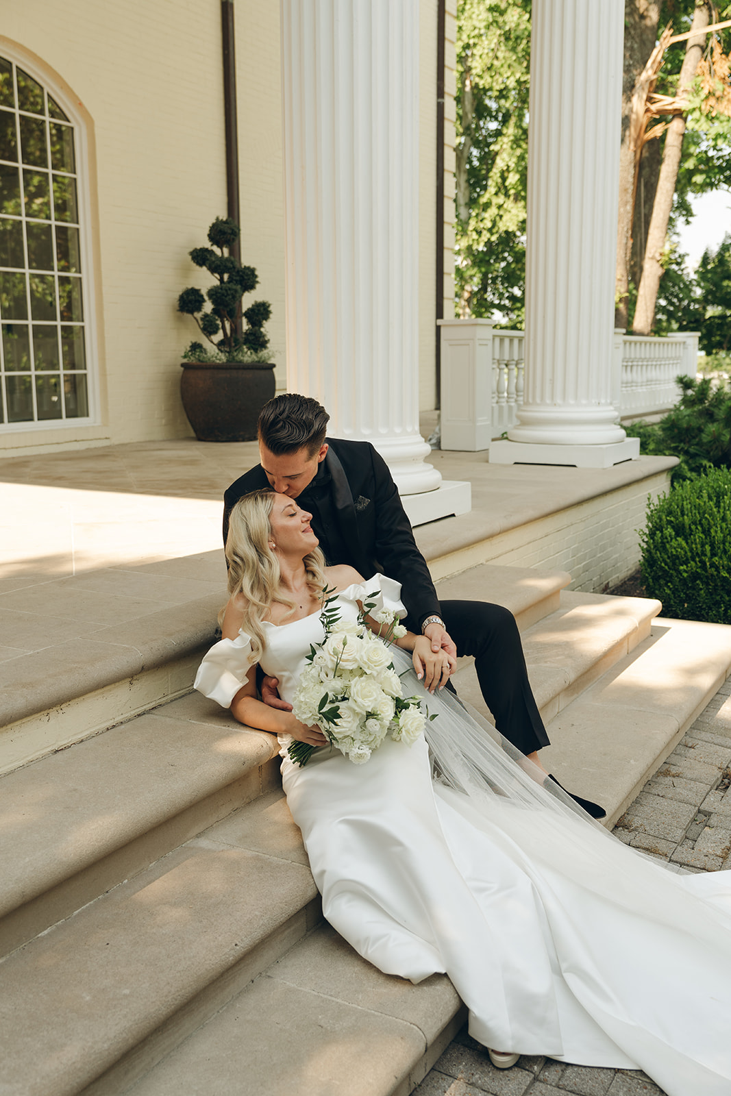 groom kissing the bride on the forehead at the Estate at Cherokee Dock