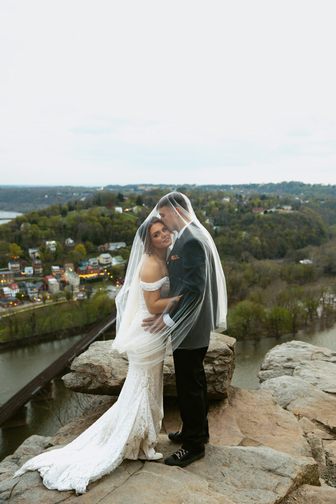 picture of the groom kissing the bride on the cheek 