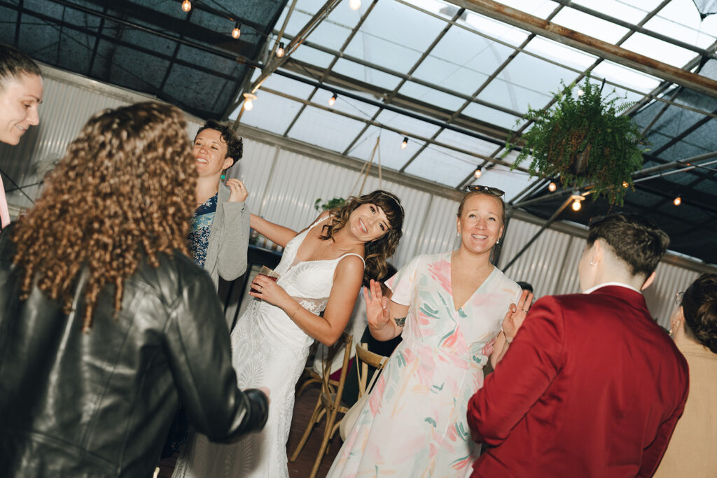 stunning bride dancing with her colorful wedding day guests 